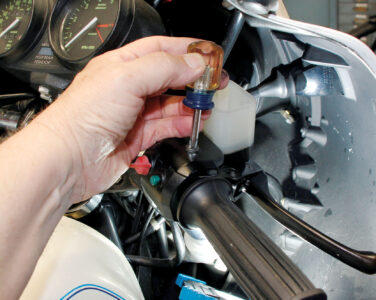 A hand removing the cables to the carburetors